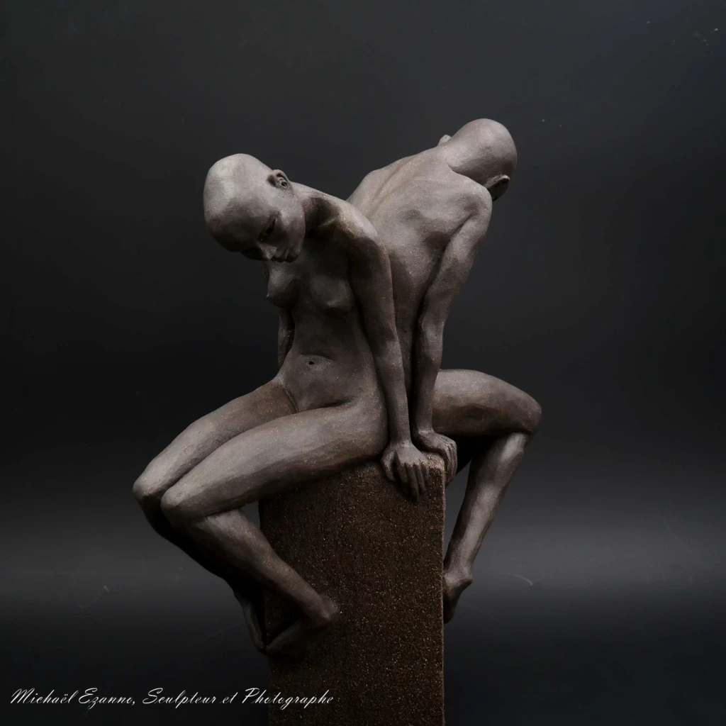 Sculpture contemporaine en grès noir par Michaël Ezanno, sculpteur en Vendée, représentant deux corps humains assis dos à dos.